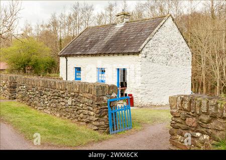 Traditional white and blue painted Irish cottage with a stone wall and blue painted gate Stock Photo