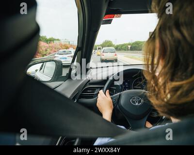 Mallorca, Spain - Jun 28, 2023: A woman behind the wheel of a Toyota navigating through daytime traffic in Mallorca, Spain Stock Photo