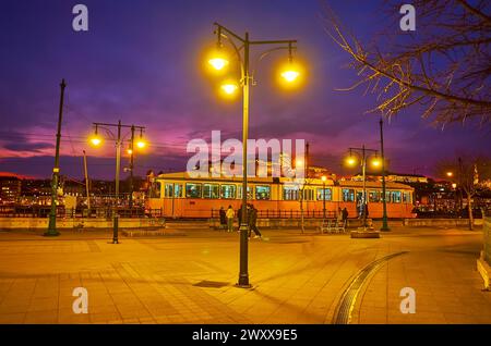 Bright evening illumination of Vigado Square with a view on the tram and Buda Castle in background, Budapest, Hungary Stock Photo