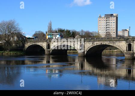 Stagecoach buses crossing historic Skerton Bridge over River Lune in Lancaster, Lancashire, England at high tide on 30th March 2024. Stock Photo
