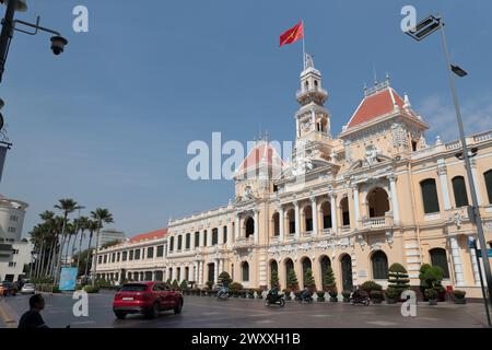 Exterior view of Peoples Committee Building, sunshine and blue sky, Vietnamese National flag flying, Ho Chi Minh City (Saigon),  Vietnam Stock Photo