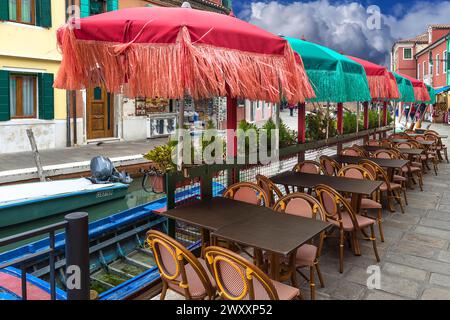 Colourful parasols in a restaurant on the canal, Burano, Venice, Veneto, Italy Stock Photo