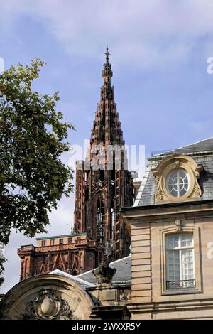 Cathedral of Our Lady of Strasbourg, Cathedrale Notre Dame de Strasbourg, Pointed brick tower of a cathedral rises into the cloudy sky, Strasbourg Stock Photo