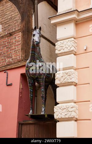 Horse sculpture with colourful lettering looks between a narrow passage between two buildings in the city of horses Warendorf, district of Warendorf Stock Photo
