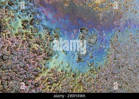 Multi-color car's lubricating oil on the road after the rain Stock Photo