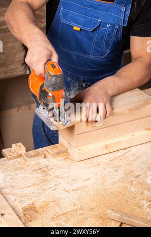 A carpenter using a jigsaw to cut wood cuts bars. Stock Photo