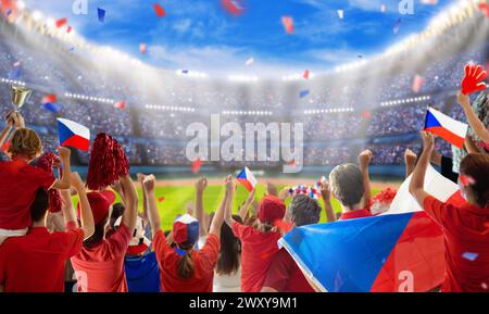 Czechia football supporter on stadium. Czech fans cheer on soccer pitch watching winning team play. Group of supporters with flag and national jersey Stock Photo