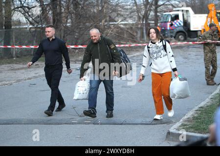 Non Exclusive: DNIPRO, UKRAINE - APRIL 02, 2024 - People carry their belongings out of the building of an educational institution damaged by a Russian Stock Photo