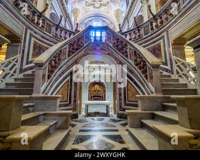 Double horseshoe-shaped polychrome marble staircase, work of Luca Carimini  (second half of the 19th century) in the Crypt - Basilica dei Santi XII Apostoli - Rome Italy Stock Photo