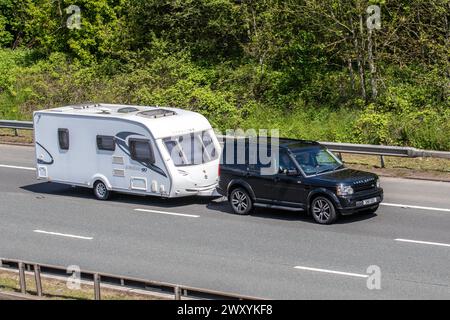 2011 Black Land Rover Discovery Sdv6 LE Landmark towing Sterling Exxles 90 caravan, motoring on the M6 motorway, UK Stock Photo