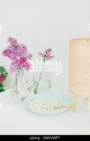 White and purple lilac on a decorating table with Scandinavian lamp Stock Photo