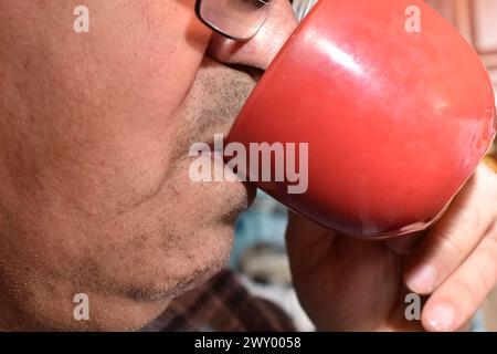 The picture shows an elderly man drinking from a cup. Stock Photo