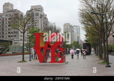 Taipei, Taiwan, March 26, 2024: Iconic love sign in front of the entrance to Taipei 101 building in the citycenter of Taipei. Rainy day, spring Stock Photo