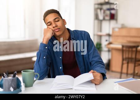 Exhausted student guy asleep on study books Stock Photo