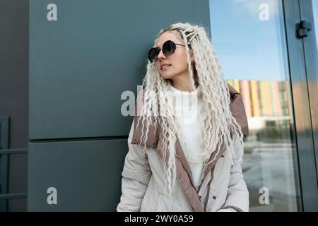 Woman With White Dreadlocks Leaning Against a Wall Stock Photo