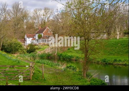 The Mill House in a picturesque setting next to a stream and pond in early spring in Nutbourne near Pulborough in rural West Sussex, England. Stock Photo