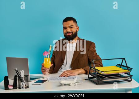 A man is immersed in work, sitting at a desk with a laptop open in front of him. He is focused and concentrated on the task at hand. Stock Photo