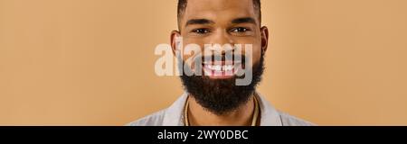 A man with a full, bushy beard grins warmly at the camera, his eyes sparkling with happiness and a hint of mischief. Stock Photo