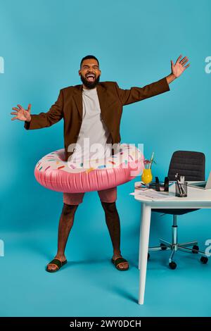 A sharply dressed man in a suit is playfully holding a large inflatable doughnut in his hands, showcasing a whimsical and unexpected sight. Stock Photo