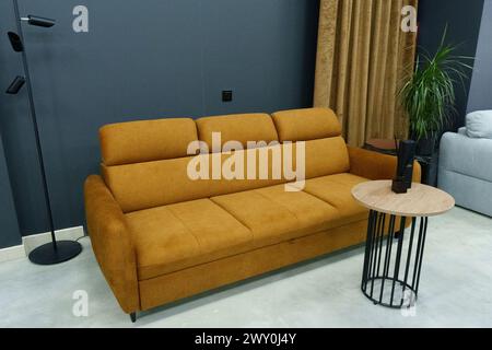 Yellow soft sofa in the interior against a black wall Stock Photo
