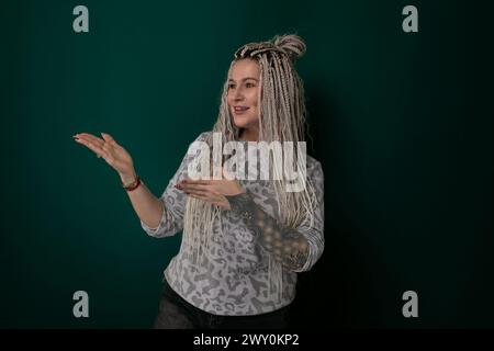 Woman With Long Blonde Hair in Front of Green Wall Stock Photo
