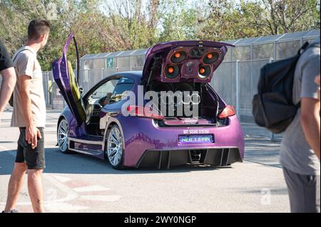 An unrecognizable Peugeot 206 GTI fully tuned with scissor doors. It is full of speakers with sound power, parking music Stock Photo