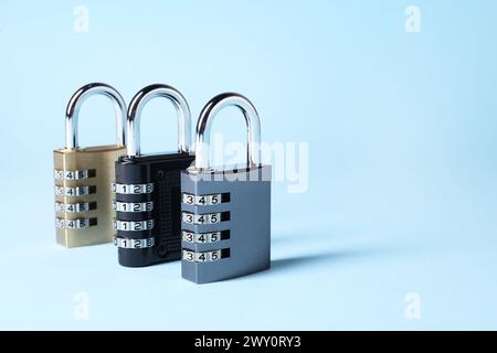 Steel combination padlocks on light blue background. Space for text Stock Photo