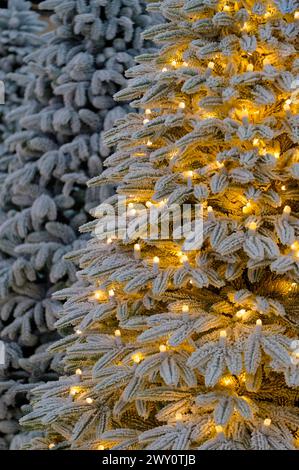 Artificial Christmas tree decorated with light bulbs and frost, close-up shot, selective focus, abstract seasonal background Stock Photo
