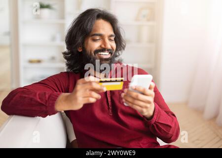 Happy man shopping online with card at home Stock Photo