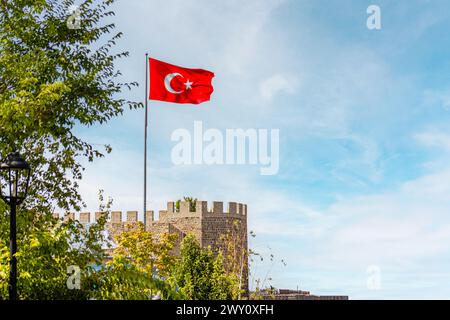 Erzurum Kalesi or Turkish flag flying proudly above Erzurum Castle under a clear sky. Stock Photo
