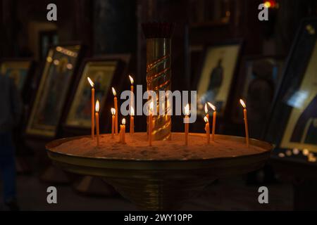 Burning candles in front of icons Stock Photo