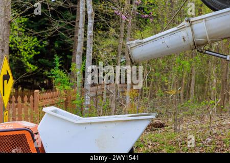 During construction wet cement is coming down cement truck chute being placed into wheelbarrow track concrete buggy Stock Photo