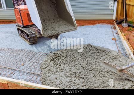 Concrete buggy truck is used to pour wet cement into framework during foundation construction Stock Photo