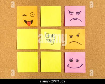 cork board with colorful post its representing various emoticons with various emotions communication concept Stock Photo