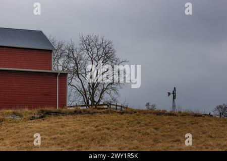 Agricultural landscape with barn on a hill and a windmill in this country side scene in rural Virginia, USA. Stock Photo