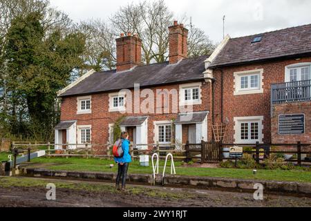 Woman viewing the lock side cottages on the Shropshire union canal as it passes through Tyrley Locks near Market Drayton Shropshire England Stock Photo