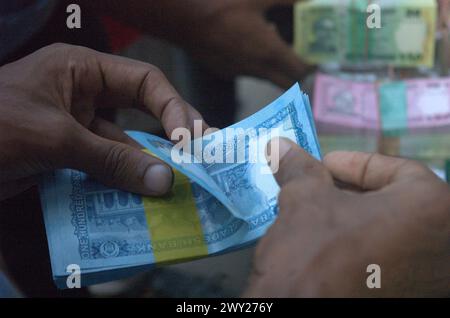 Dhaka, Bangladesh. 4th Apr, 2024. After buying from a roadside shop in Dhaka, a man counts Bangladeshi 100 taka bank notes. (Credit Image: © MD Mehedi Hasan/ZUMA Press Wire) EDITORIAL USAGE ONLY! Not for Commercial USAGE! Stock Photo