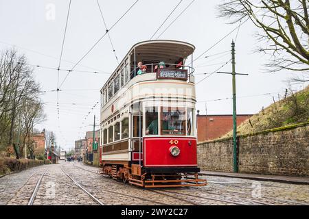 Tram travelling over the cobblestones seen at the National Tramway Museum near Matlock, Derbyshire in April 2024. Stock Photo