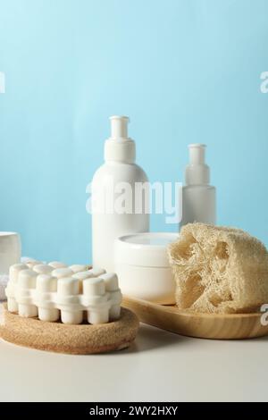 Set of bath supplies with loofah sponge and plant branches on white ...