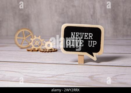 Never give up words written on the chalkboard. Stock Photo