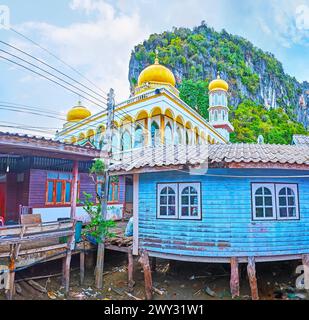 THe golden domes of the mosque behind the wooden stilt houses of Ko Panyi floating village, Phang Nga Bay, Thailand Stock Photo