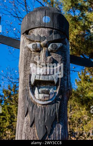 Closeup of carved face of wooden totem pole used long ago to protect communities from evil located in public park near Daejeon, South Korea Stock Photo