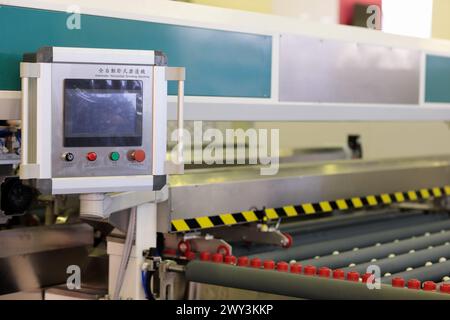 Automatic horizontal glass edge grinding machine. Selective focus. Stock Photo