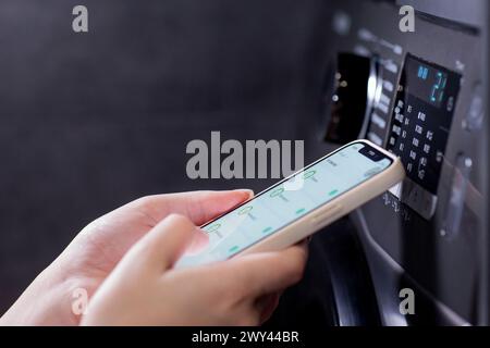 Woman controls washing machine with a phone Stock Photo
