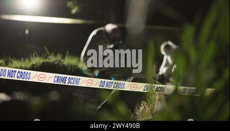 Crime scene, photography and investigator with evidence outdoor for analysis and investigation in forest or nature. People, detective or forensic Stock Photo