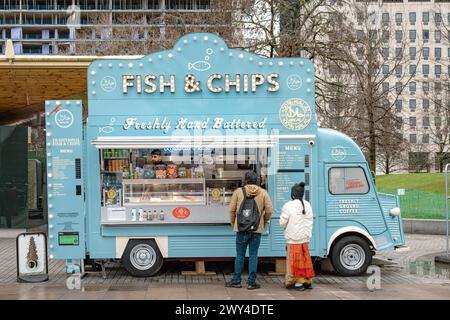 Customers waiting for their food at a mobile fish and chips van selling 100% halal meals in London. Travel, culture, small business or diet concept. Stock Photo