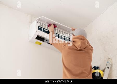 Professional technician maintaining modern air conditioner indoors. High quality photo Stock Photo