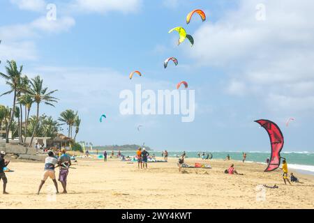 Crowd of active sporty people enjoying kitesurfing holidays and activities on perfect sunny day on Cabarete tropical sandy beach in Dominican Republic Stock Photo