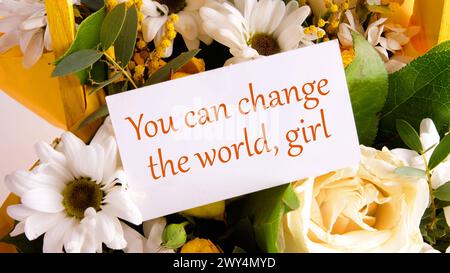 You can change the world, girl text written on a business card on a background of flowers Stock Photo