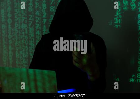 Hacker using cell phone for hacking Stock Photo
